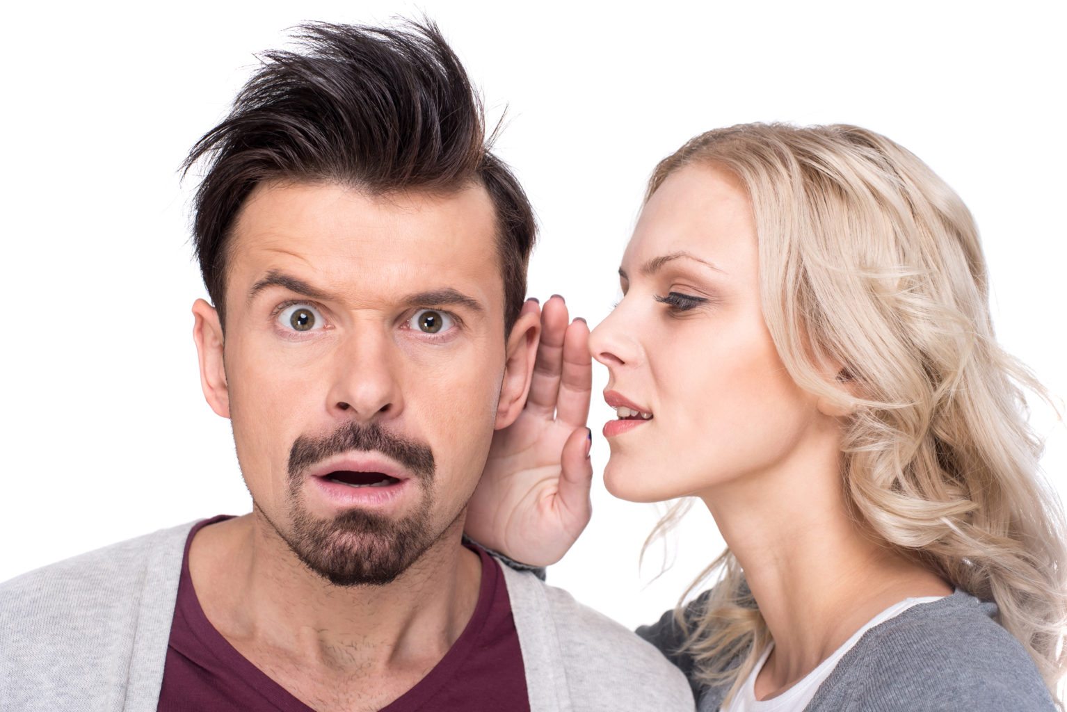 Amazed man is listening gossip in the ear from woman on the white background.